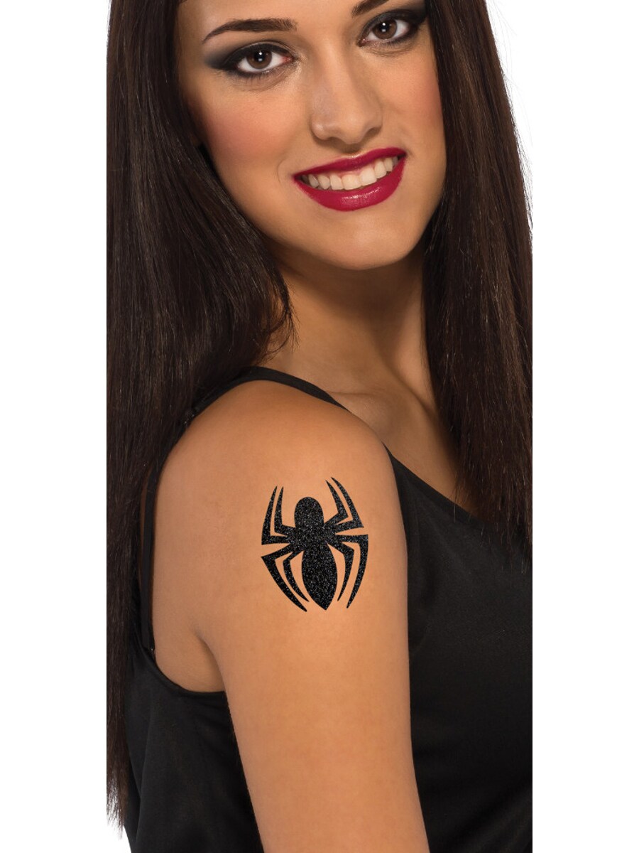 Professional young tattoo girl in black gloves making a black spider tattoo  on the girl arm -